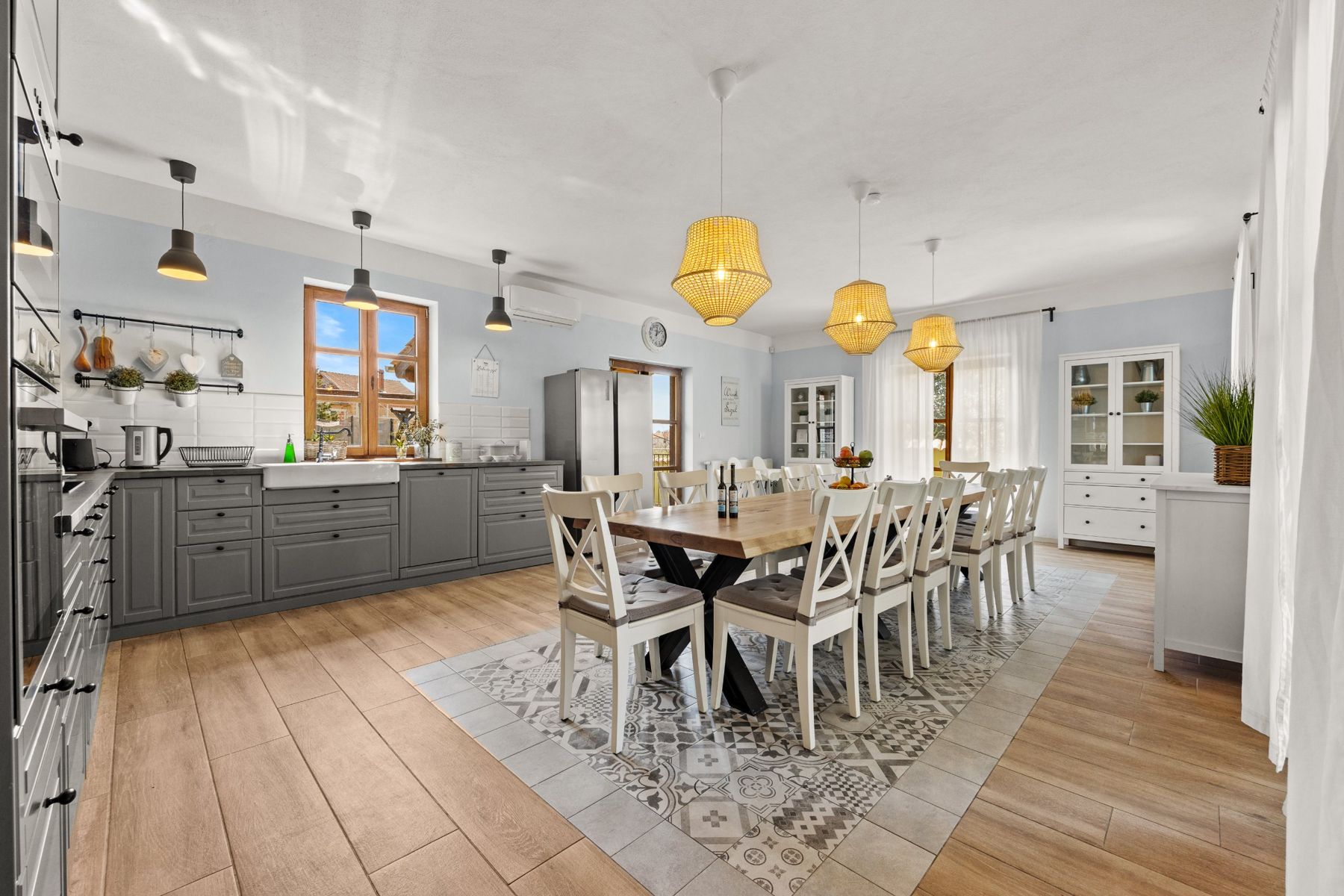 The open kitchen and long dining table with patterned floor tiles