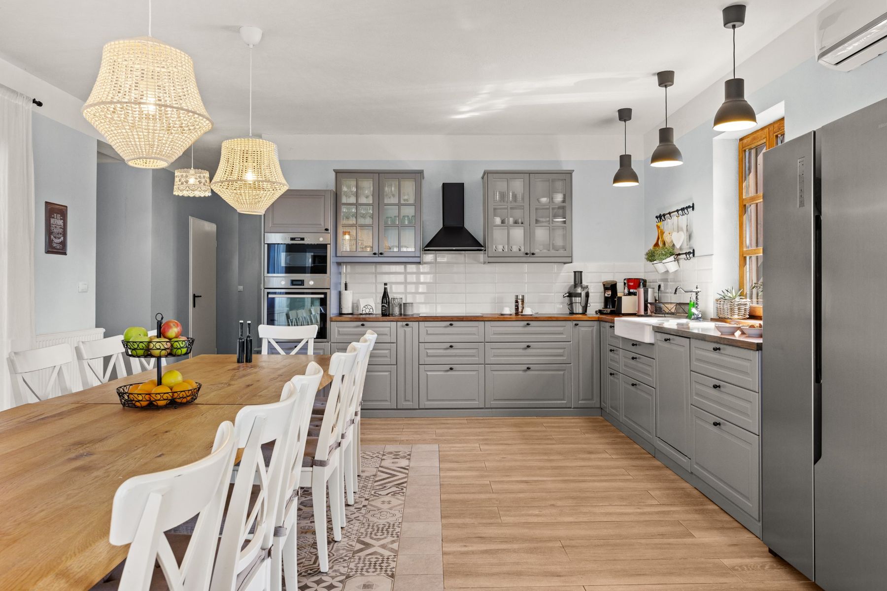 The grey kitchen with built-in ovens, hob and farmhouse sink