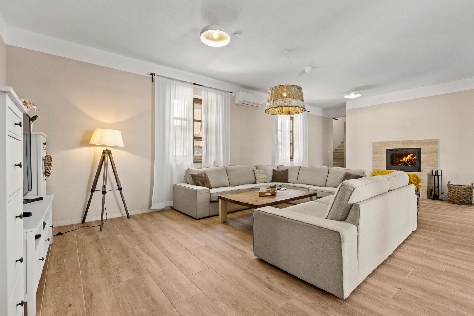 The living room with a large sofa, coffee table and fireplace