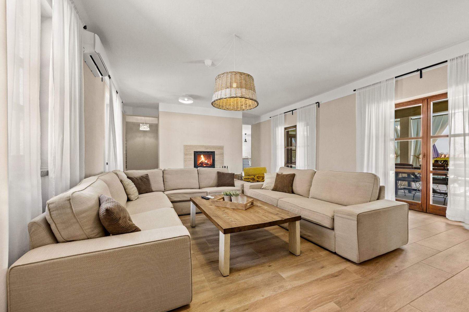 Living room sofas facing the fireplace, with doors to the terrace