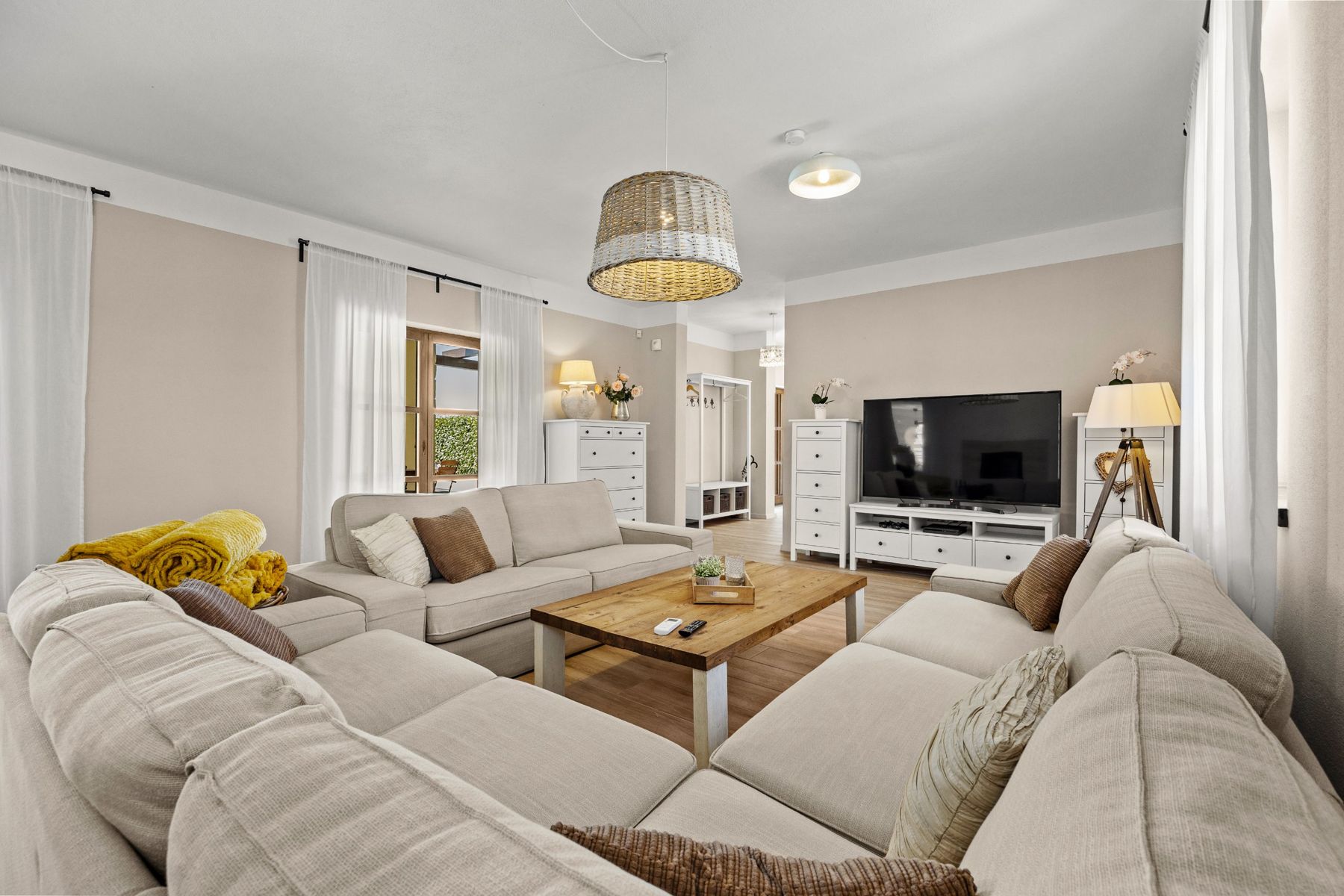 The living room with a large TV and white storage furniture